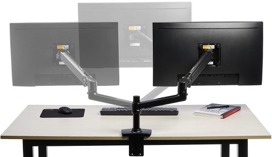 Vista trasera de un escritorio con un brazo articulado en negro sujetando un monitor de ordenador